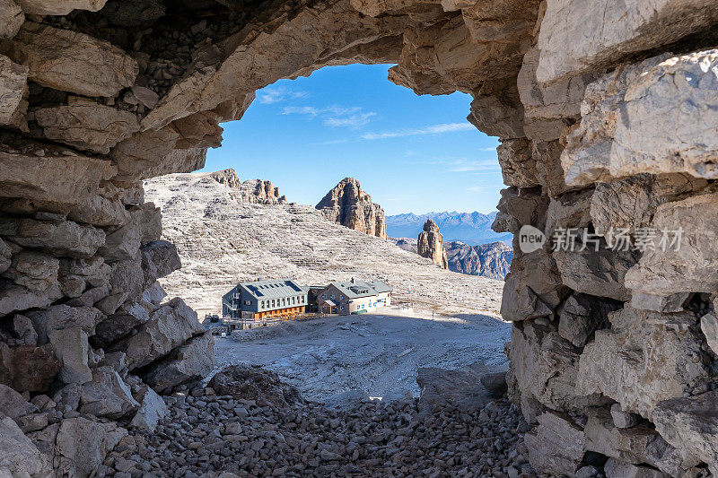 透过石堆中的石窗，可以看到rifugio Boe山间小屋。白云石，意大利阿尔卑斯山。萨拉地块